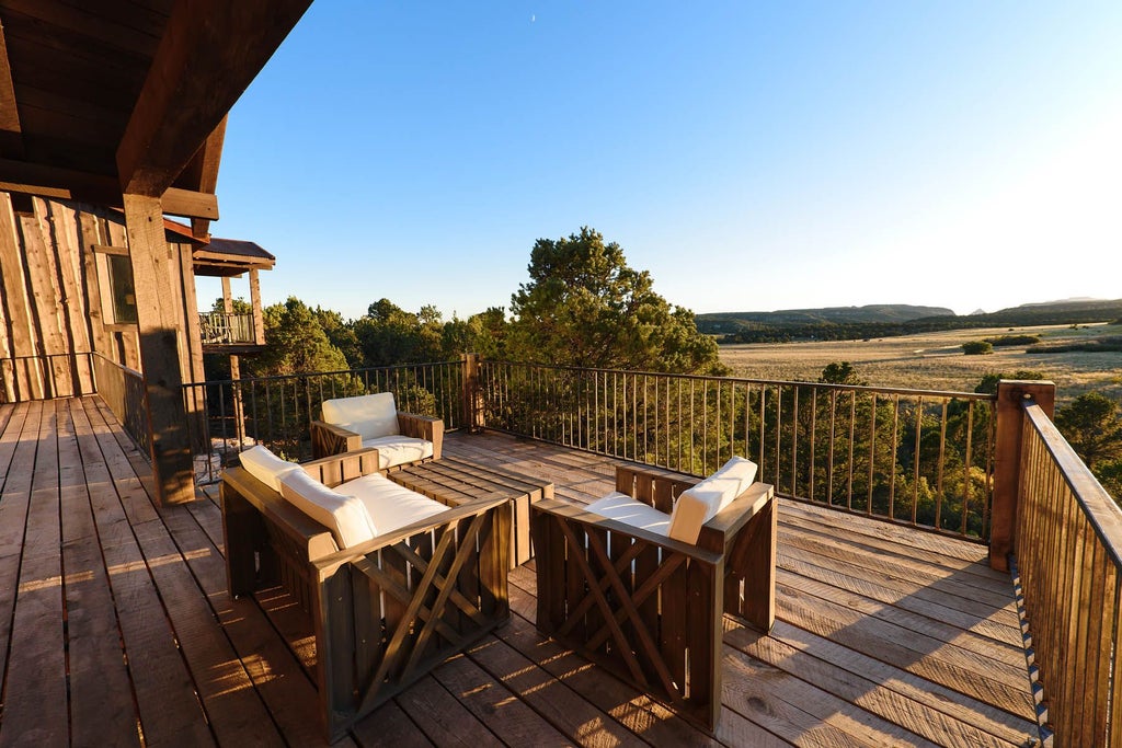 Rustic lodge room with wooden furnishings, plush bedding, and panoramic mountain views at Zion Mountain Ranch in the scenic United States Southwest