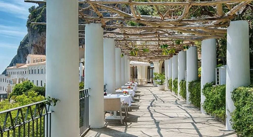 Cliffside luxury hotel in Amalfi with infinity pool overlooking Mediterranean Sea, set in restored 13th-century monastery complex