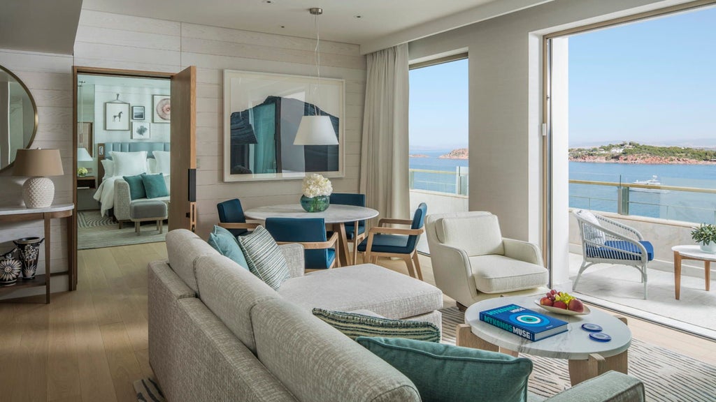 Elegant one-bedroom suite with panoramic Mediterranean views, featuring modern furnishings, private terrace and floor-to-ceiling windows.