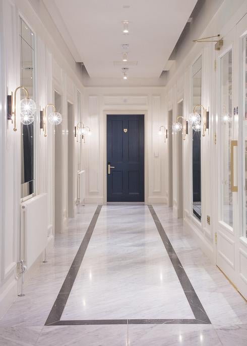 Elegant boutique hotel entrance featuring ornate Victorian architecture, brass fixtures, and crimson red door with potted plants