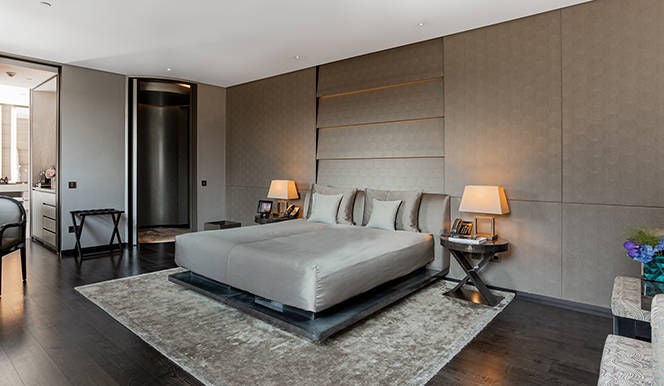 Spacious designer hotel room with limestone bathroom, custom Armani furnishings, and elegant neutral tones in Milano