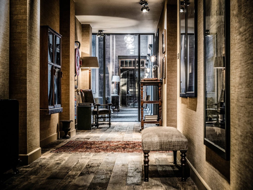 Historic townhouse-style boutique hotel with elegant gray stone facade, ornate windows, and black wrought iron details in Ghent's old town