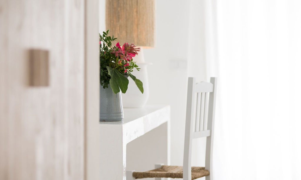 Elegant light-filled superior room at Octant Vila Monte resort, featuring minimalist white decor, natural wood accents, and large windows overlooking Portuguese landscape