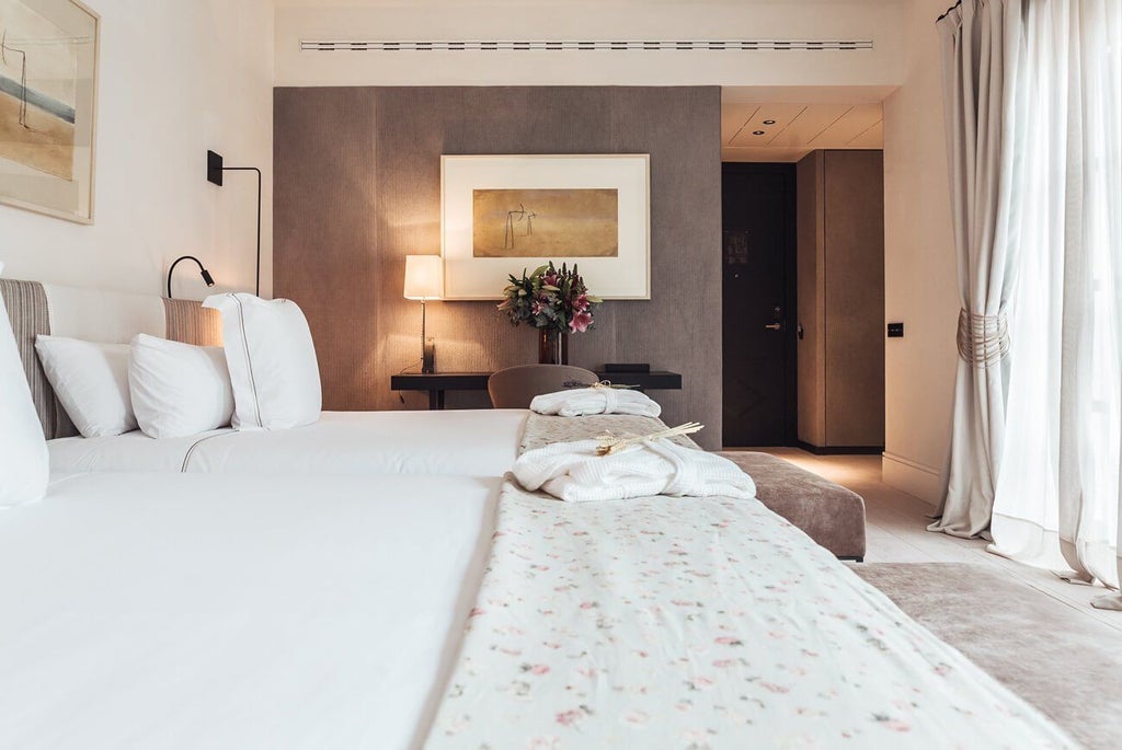 Luxurious beige and white privilege room at Sant Francesc Hotel Singular, featuring elegant decor, plush bedding, and contemporary Spanish architectural design