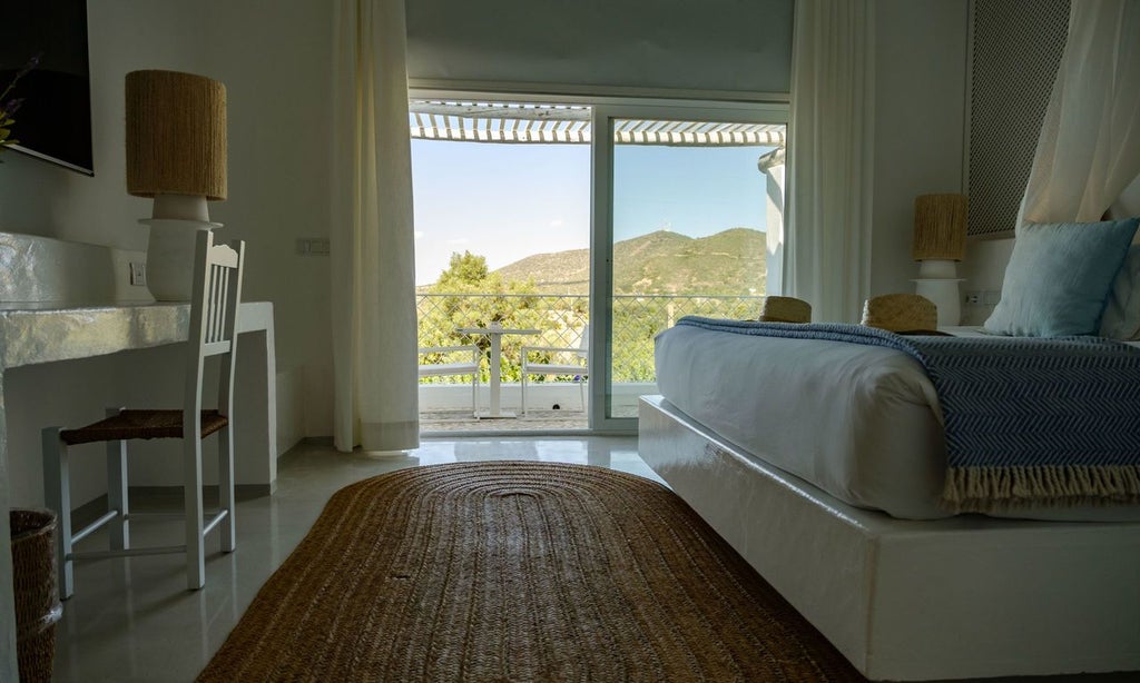 Sunlit Portuguese boutique hotel room with minimalist white decor, natural wood accents, and elegant king-sized bed overlooking lush garden scenery