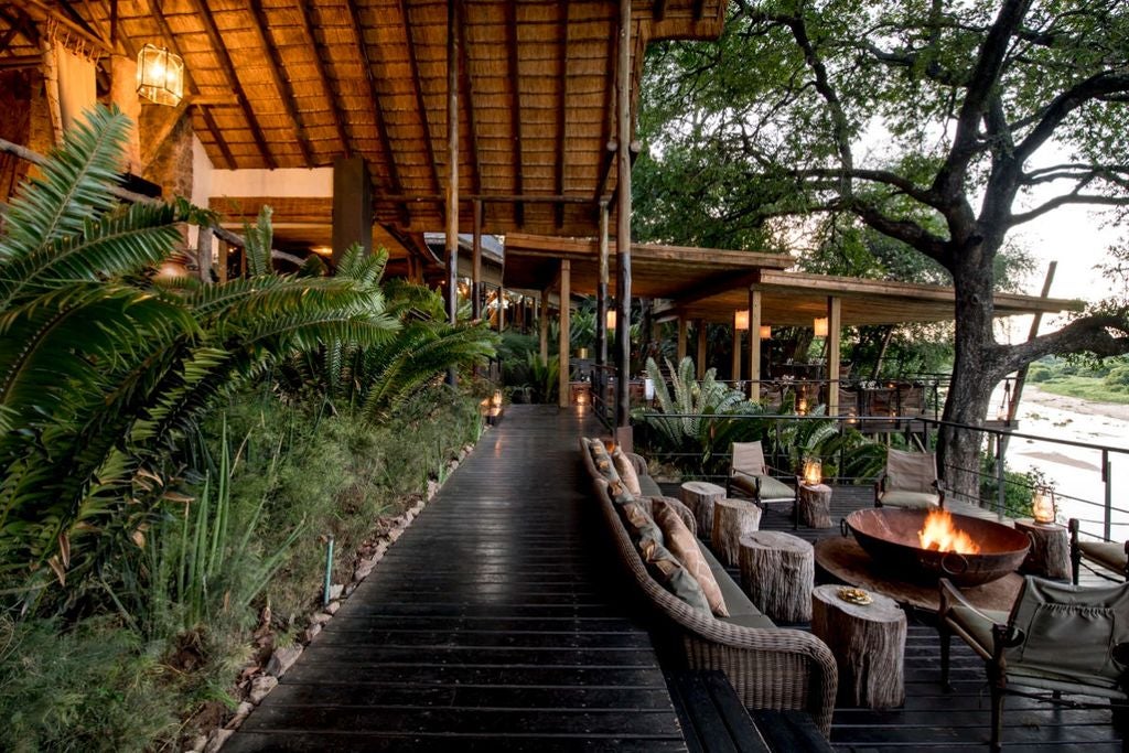 Luxurious treehouse-style suite at Singita Ebony Lodge, featuring private deck overlooking African bush with plunge pool and lounge area