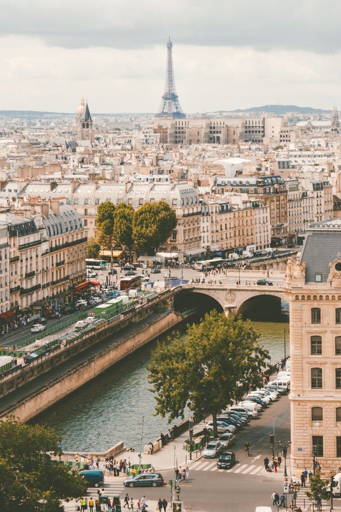 Colorful sunset illuminates iconic Eiffel Tower with romantic pink-orange sky, couples dining at elegant sidewalk cafes in Parisian scene