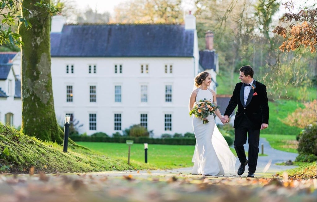 Elegant stone manor house nestled in lush Welsh countryside, soft golden light illuminating historic architectural details and manicured gardens of luxury boutique hotel