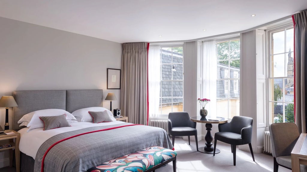 Elegant superior deluxe hotel room with classic British design, featuring luxurious wooden furnishings, crisp white linens, and sophisticated period architectural details