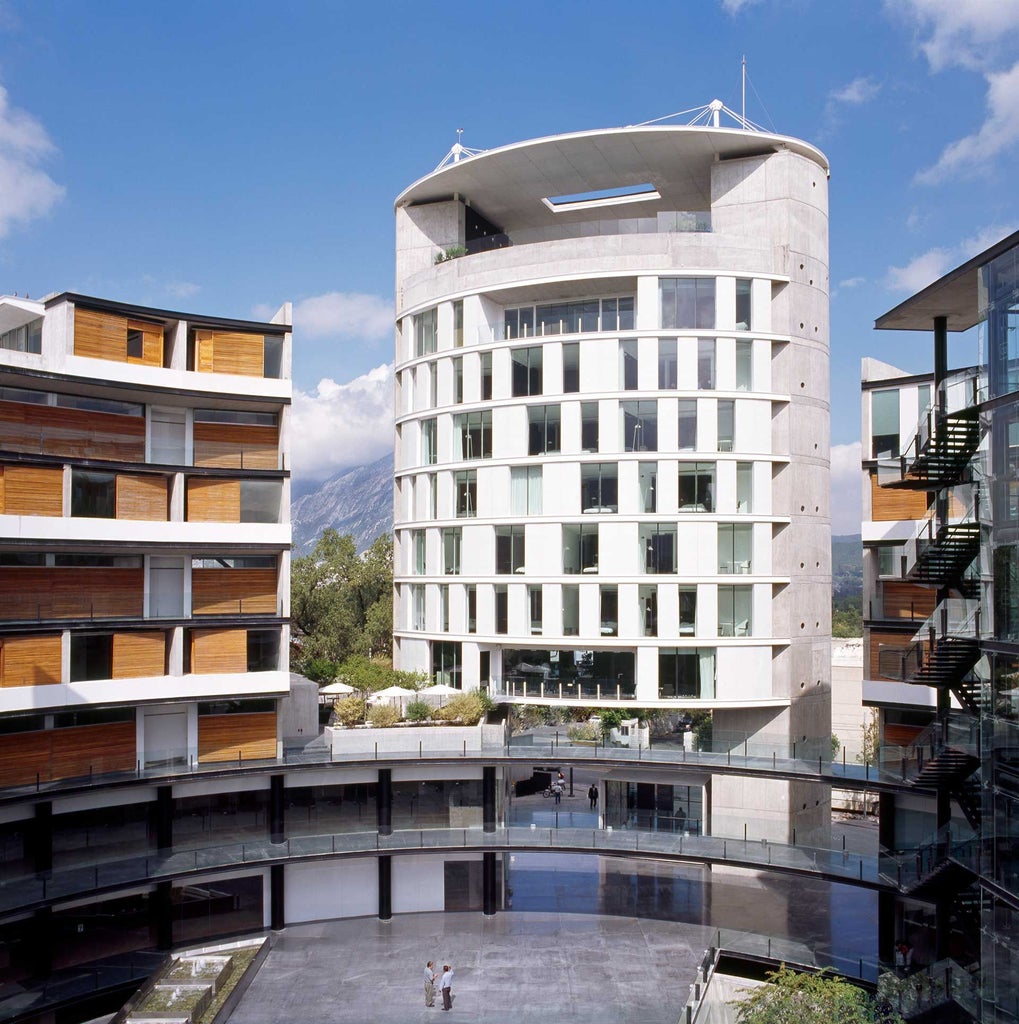 Modern metallic-gray boutique hotel with sleek architectural lines, minimalist design, and urban Mexican style overlooking Monterrey's skyline at dusk