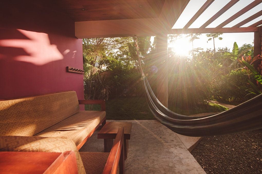 Spacious beachfront suite with contemporary design, panoramic ocean views, modern white furnishings, and elegant tropical coastal aesthetic in Costa Rica.