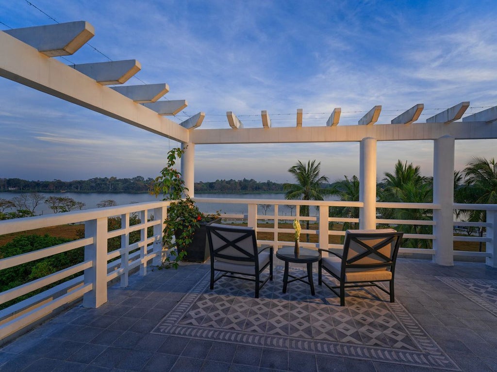 Elegant riverside suite at Azerai La Residence with French colonial design, river view, luxurious bedding, and warm natural lighting in Hue, Vietnam