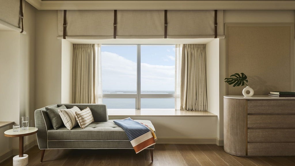 Luxurious one-bedroom suite with panoramic bay views, sleek modern design, floor-to-ceiling windows, and elegant contemporary furnishings in Miami's Four Seasons Hotel