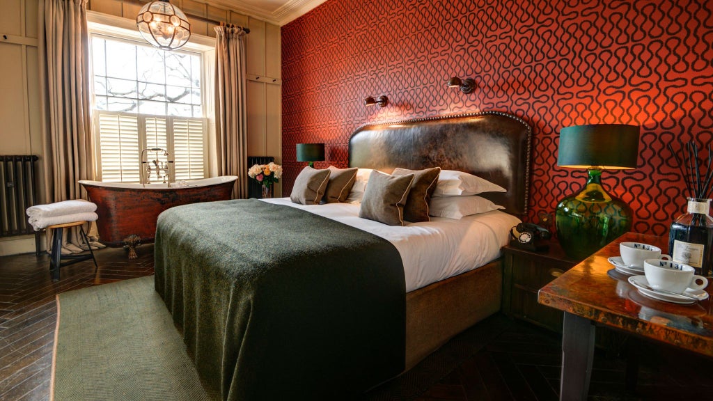 Elegant boutique hotel room with plush white bedding, contemporary wooden furnishings, soft ambient lighting, and refined neutral color palette in a UK luxury accommodation