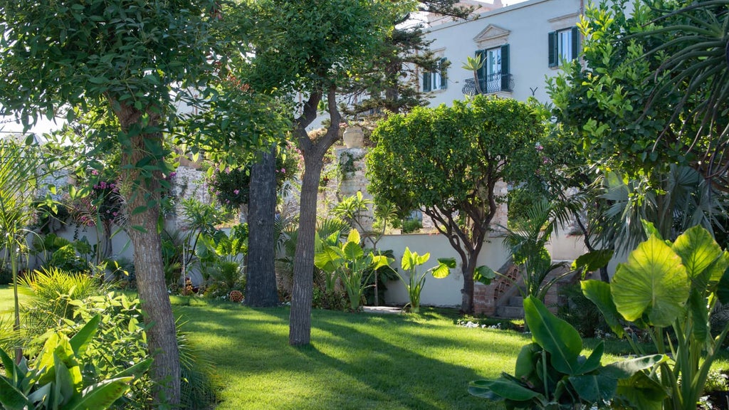 Historic luxury hotel with infinity pool overlooking Mediterranean Sea and Mount Etna, set within manicured gardens in Taormina