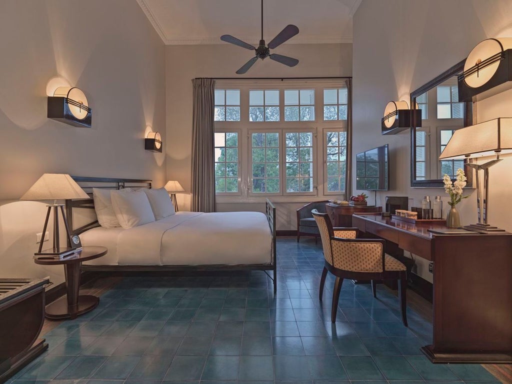 Elegant colonial-style deluxe room at Azerai La Residence, featuring vintage furnishings, soft lighting, and traditional Vietnamese architectural details in Hue