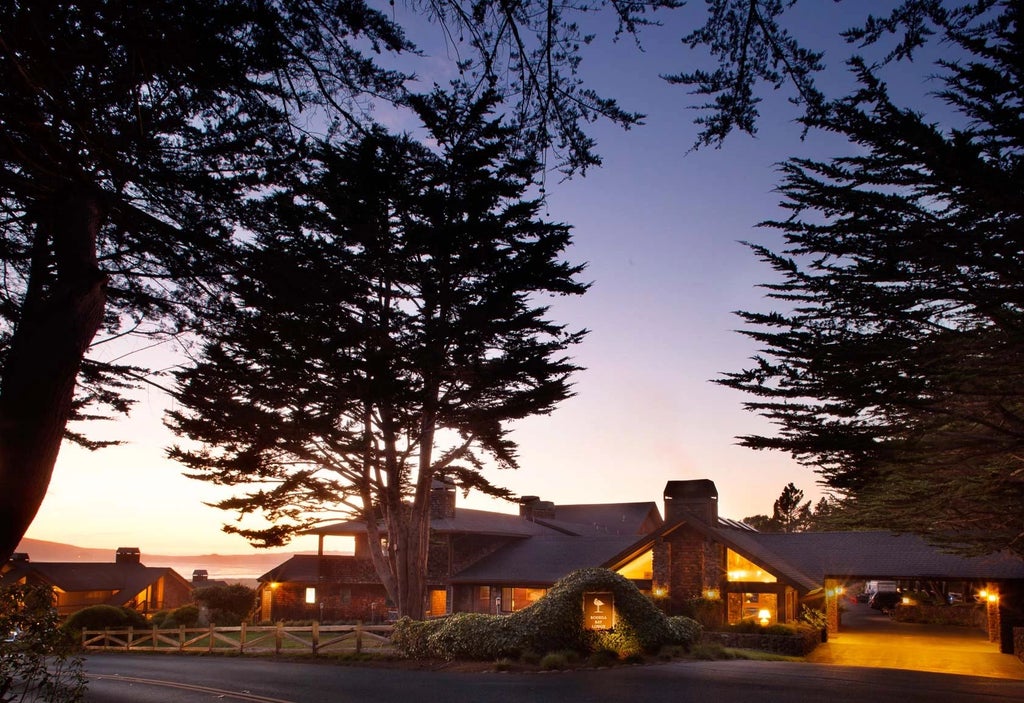 Luxurious coastal lodge nestled in scenic Bodega Bay, featuring rustic wood exterior, expansive windows, and panoramic views of rugged California shoreline