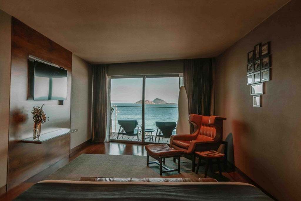 Elegant Fasano hotel room overlooking Rio's iconic Ipanema Beach, featuring panoramic ocean views, sleek contemporary design, and luxurious white decor