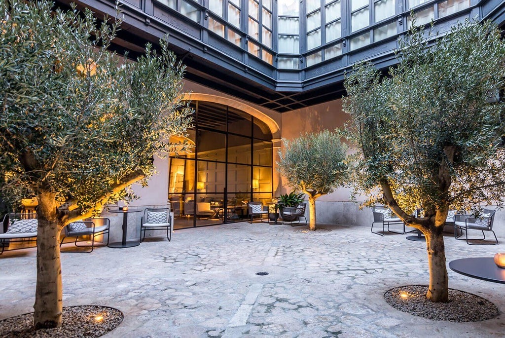 Elegant boutique hotel facade in Palma de Mallorca, featuring restored historic stone building with modern luxury design and classic Spanish architectural details