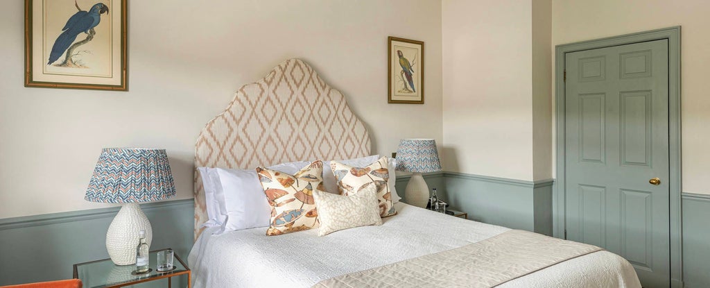 Elegant Georgian-style bedroom in classic cream and blue tones at luxury spa hotel, featuring antique furnishings and refined architectural details