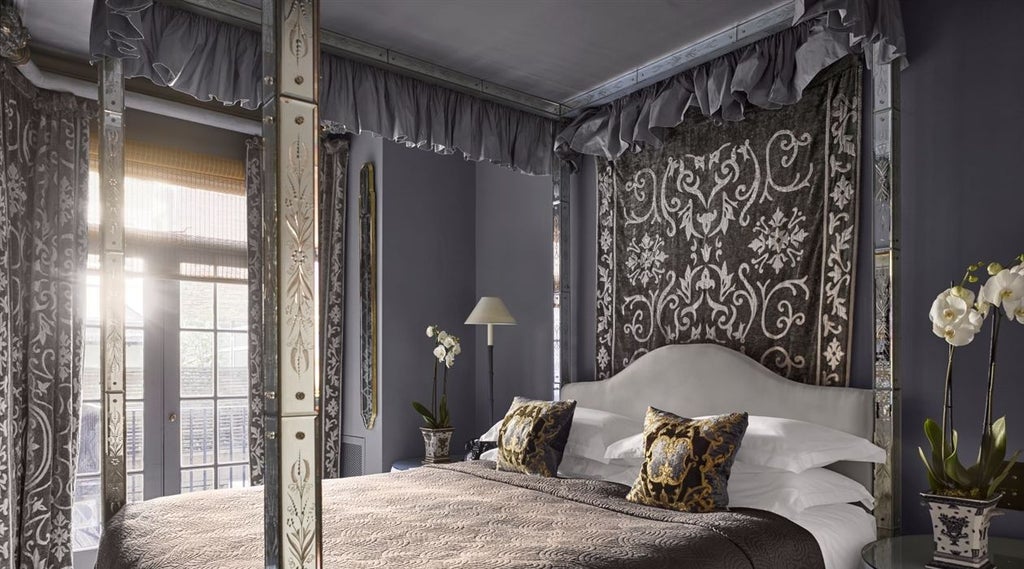 Luxurious boutique bedroom in scenset Hotel, featuring ornate dark wood furniture, plush velvet furnishings, and dramatic moody interior design aesthetic