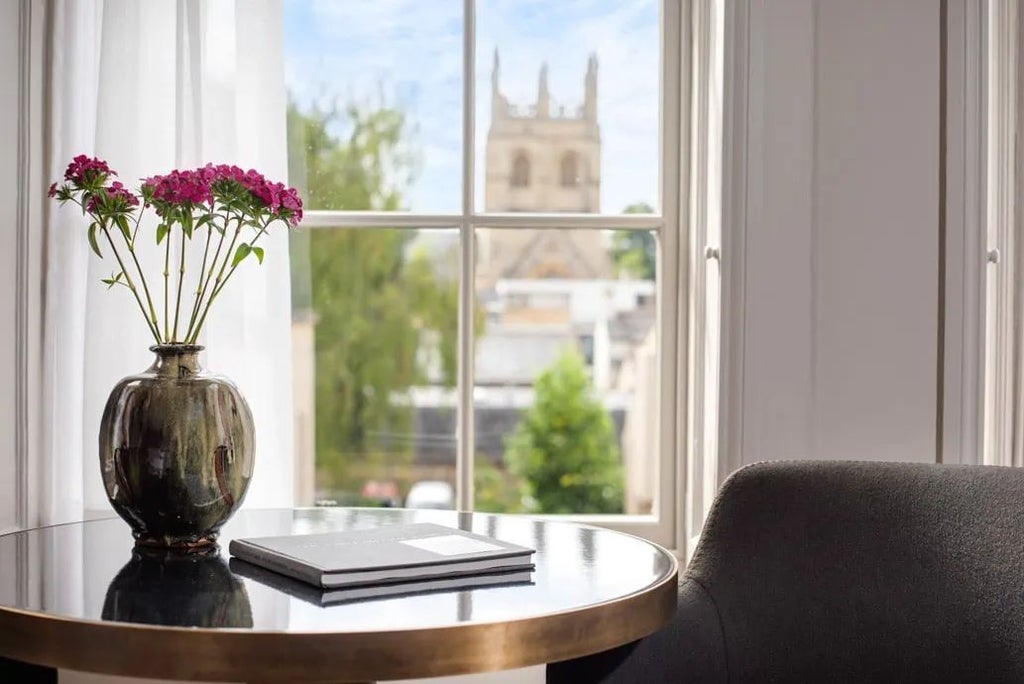 Elegant small double hotel room with classic wood furnishings, crisp white linens, and sophisticated neutral color palette in historic United Kingdom setting