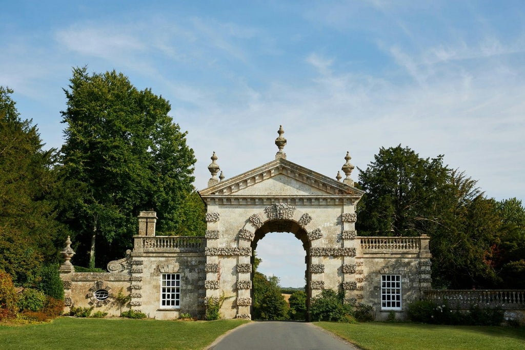 Elegant stone-fronted country inn with lush gardens, traditional British architecture, and warm inviting exterior nestled in picturesque rural landscape