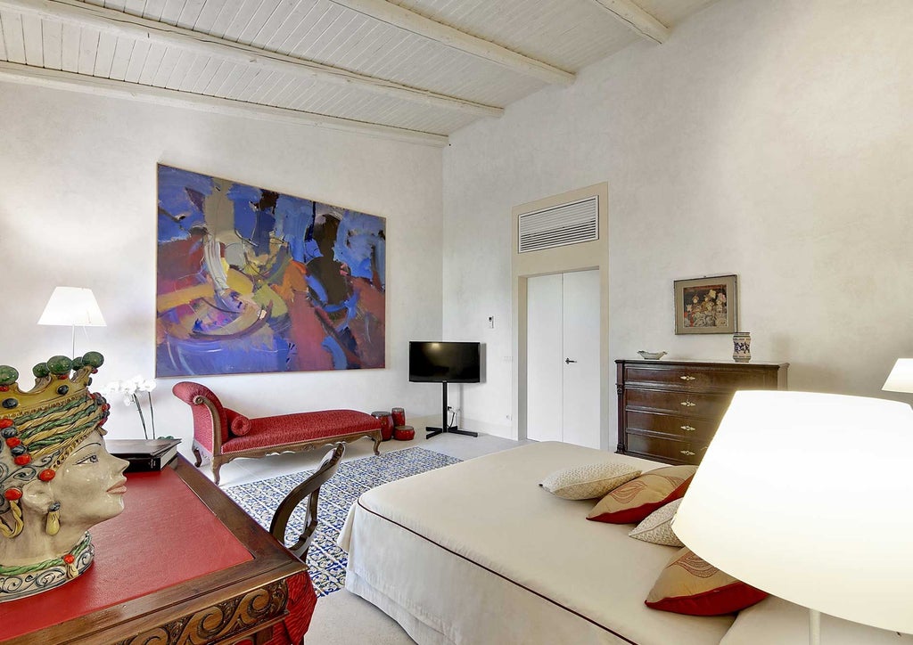 Elegant Sicilian hotel room with plush white bedding, antique wooden furniture, soft neutral tones, and traditional Mediterranean architectural details.