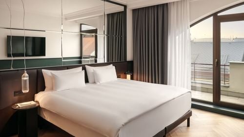 Elegant junior suite with modern Czech design, plush king bed, marble bathroom, and panoramic city views in luxurious Almanac X Alcron hotel, Prague