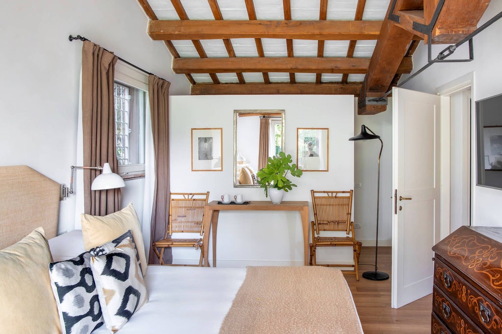 Elegant Italian boutique hotel suite with rustic stone walls, plush white bedding, and warm wooden furnishings in Tuscany's countryside