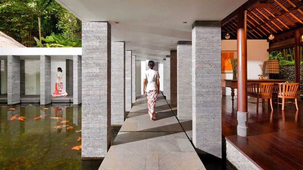 Luxurious infinity pool overlooking lush Ubud jungle at COMO Uma, with traditional Balinese architecture and verdant tropical landscape