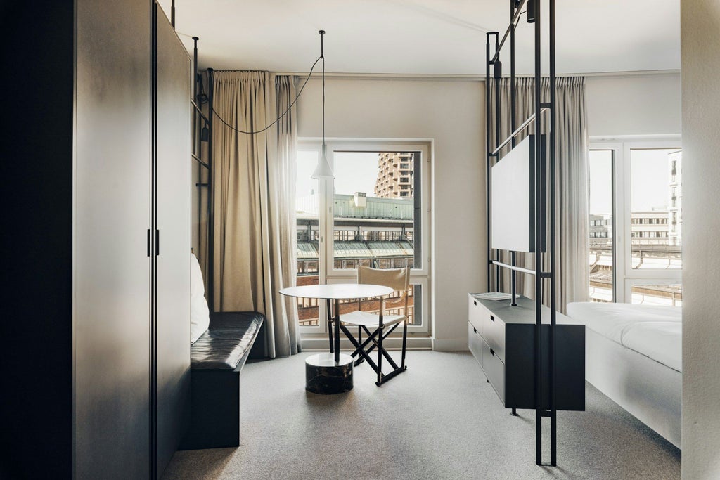 Minimalist Scandinavian hotel studio with sleek gray furnishings, large windows, modern design, and elegant neutral color palette showcasing urban Nordic luxury