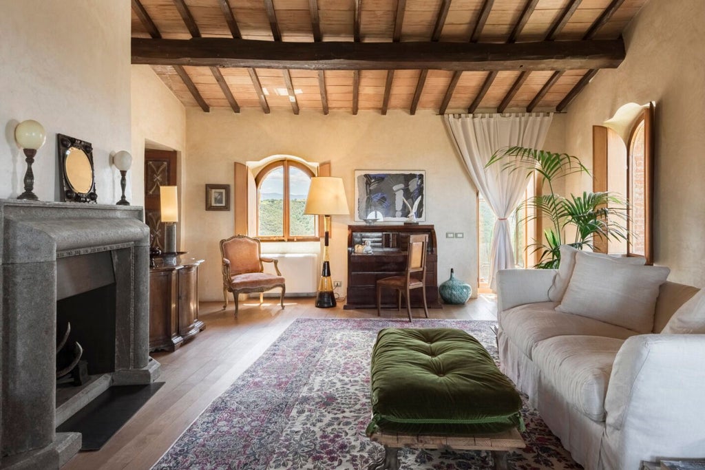 Elegant Tuscan stone suite with rustic wooden beams, luxury king bed, arched windows overlooking rolling countryside near Castello di Vicarello