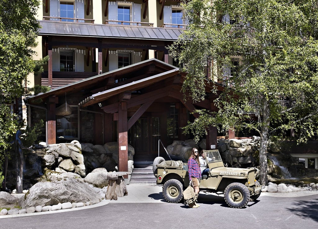 Elegant alpine-style lodge with wooden facade, surrounded by pine trees, showcasing luxurious French mountain resort architecture in scenic landscape