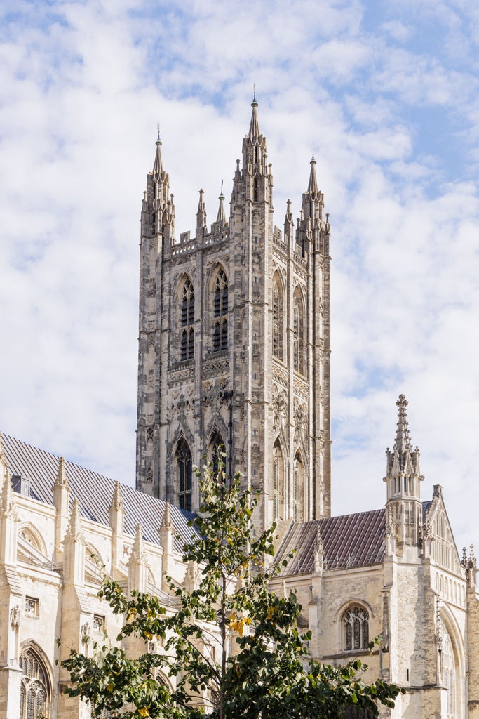 Historic Canterbury Cathedral spires towering over charming cobblestone streets and traditional Tudor buildings in Kent, England