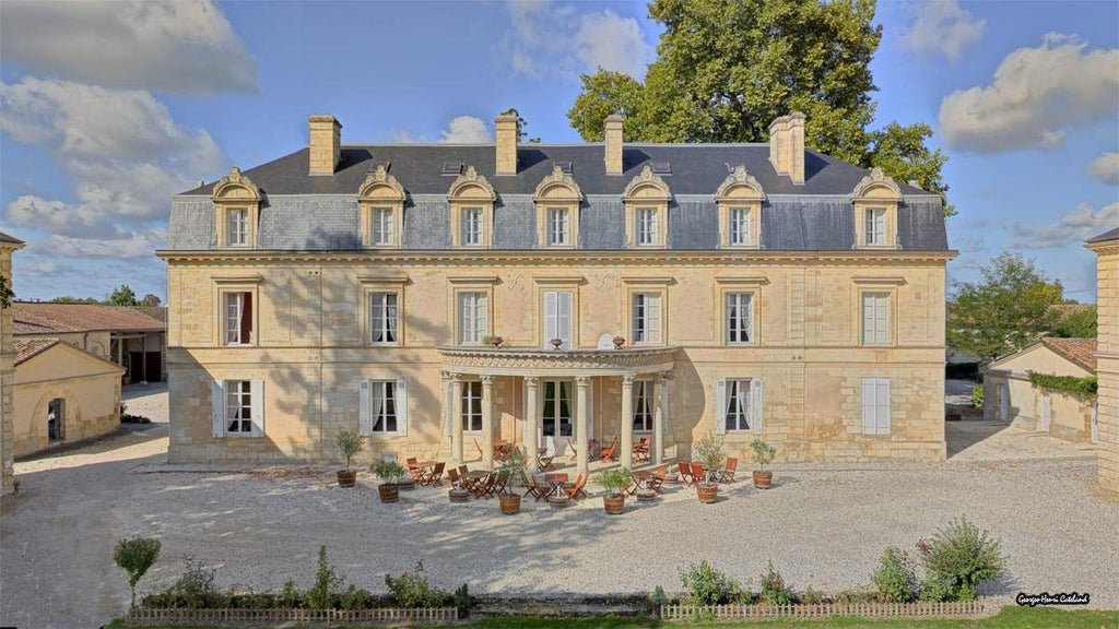 Elegant French château-style hotel nestled in lavender fields, featuring stone facade, manicured gardens, and warm golden light at sunset