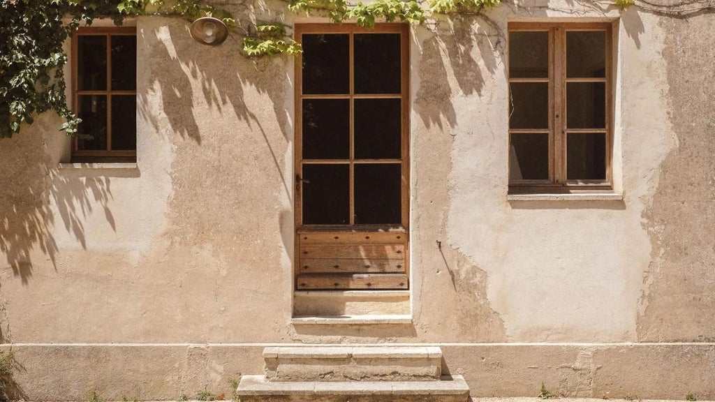 Elegant stone-facade French boutique hotel with lavender-lined terrace, soft golden lighting, and rustic Provençal architectural charm at dusk