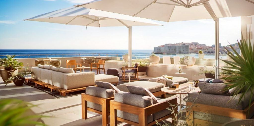 Grand limestone Hotel Excelsior overlooking the Adriatic Sea in Dubrovnik, featuring elegant terraces and a private beach with crystal waters