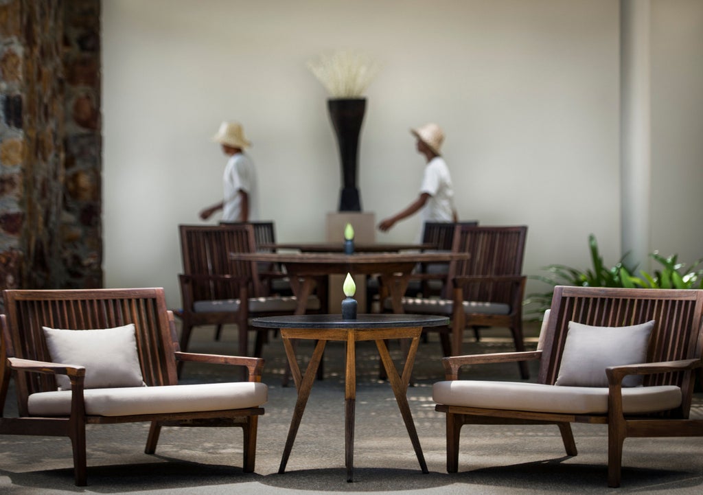 Tranquil hotel courtyard with a pristine infinity pool surrounded by elegant stone columns and tropical gardens at luxury Amansara resort