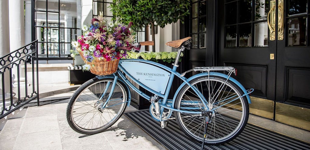 Elegant Victorian-era boutique hotel exterior with ornate architectural details, wrought-iron balconies, and classic London street scene backdrop