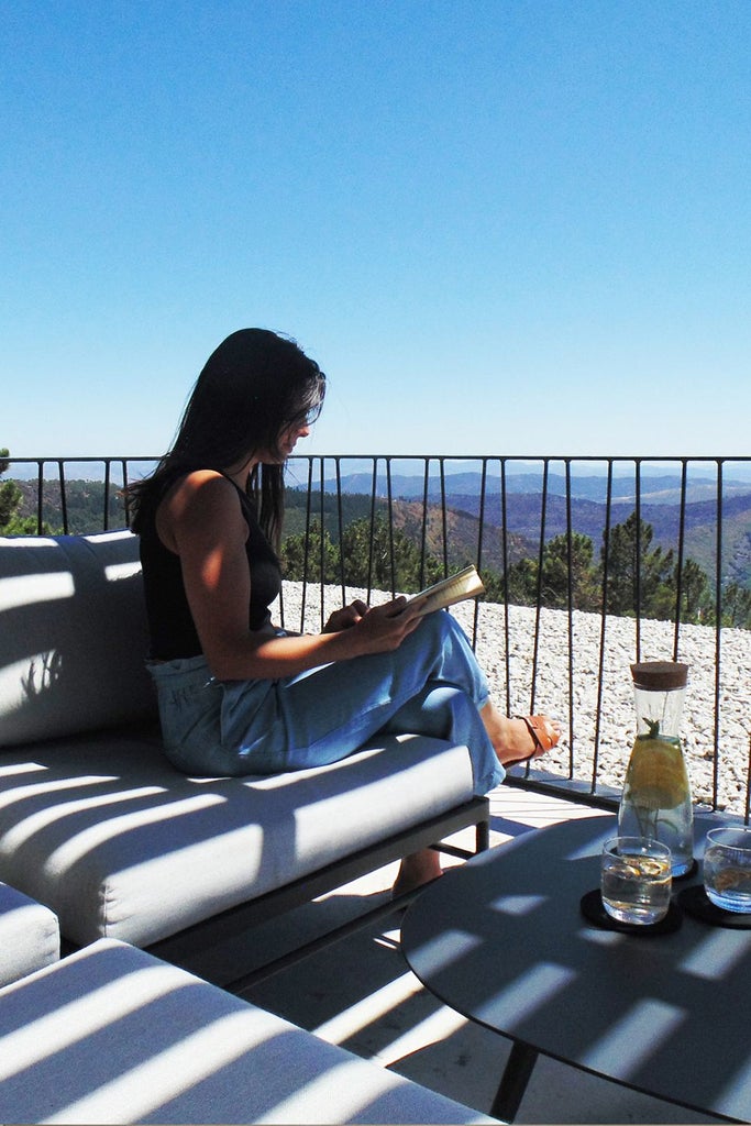 Luxurious mountain-view hotel room with elegant minimalist design, featuring warm wood tones, panoramic windows, and Maria Keil's artistic textiles in Portugal