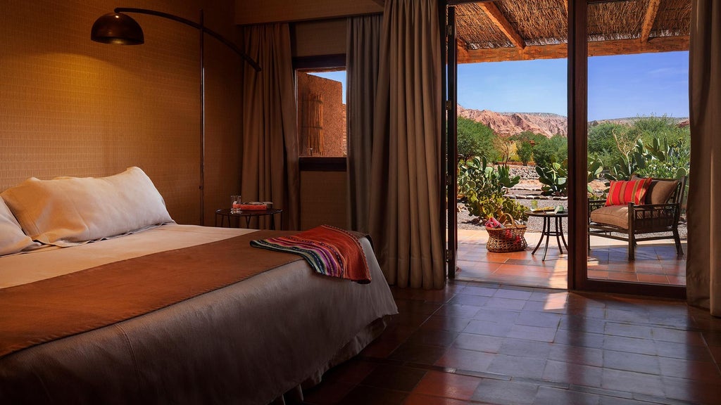 Luxurious desert lodge with adobe walls nestled against rusty-red mountains, featuring an infinity pool reflecting the Atacama sky