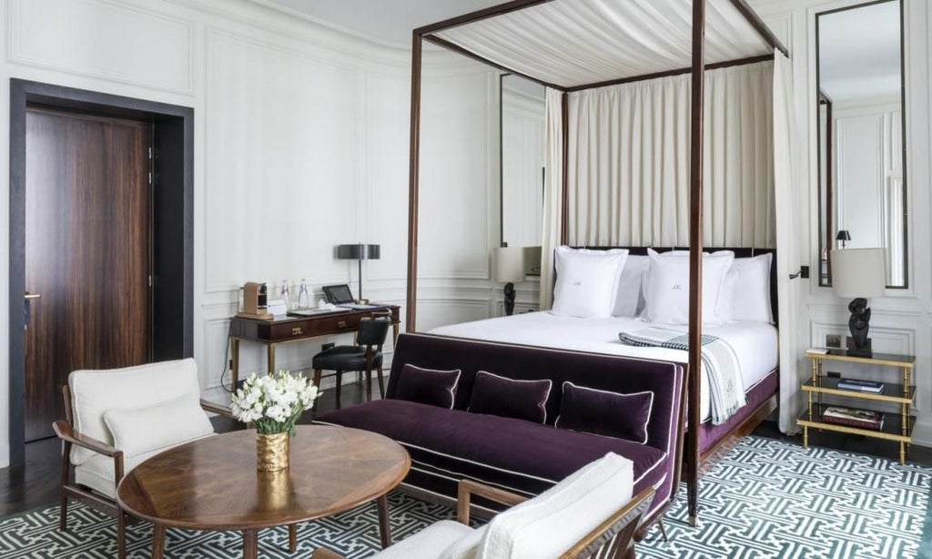 Elegant Parisian hotel master bedroom with plush white bedding, ornate chandelier, and sophisticated neutral decor reflecting French luxury design aesthetic