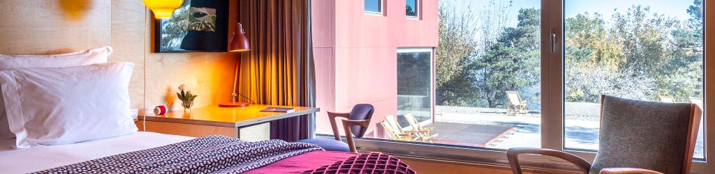 Elegant mountain-view double room with crisp white linens, wooden floors, and minimalist design at a luxury mountain lodge in Portugal