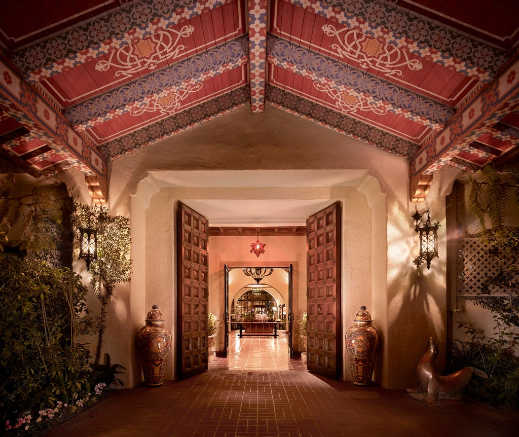 Mediterranean-style luxury resort with white stucco walls, red-tiled roofs and palm trees overlooking Santa Barbara's pristine beachfront