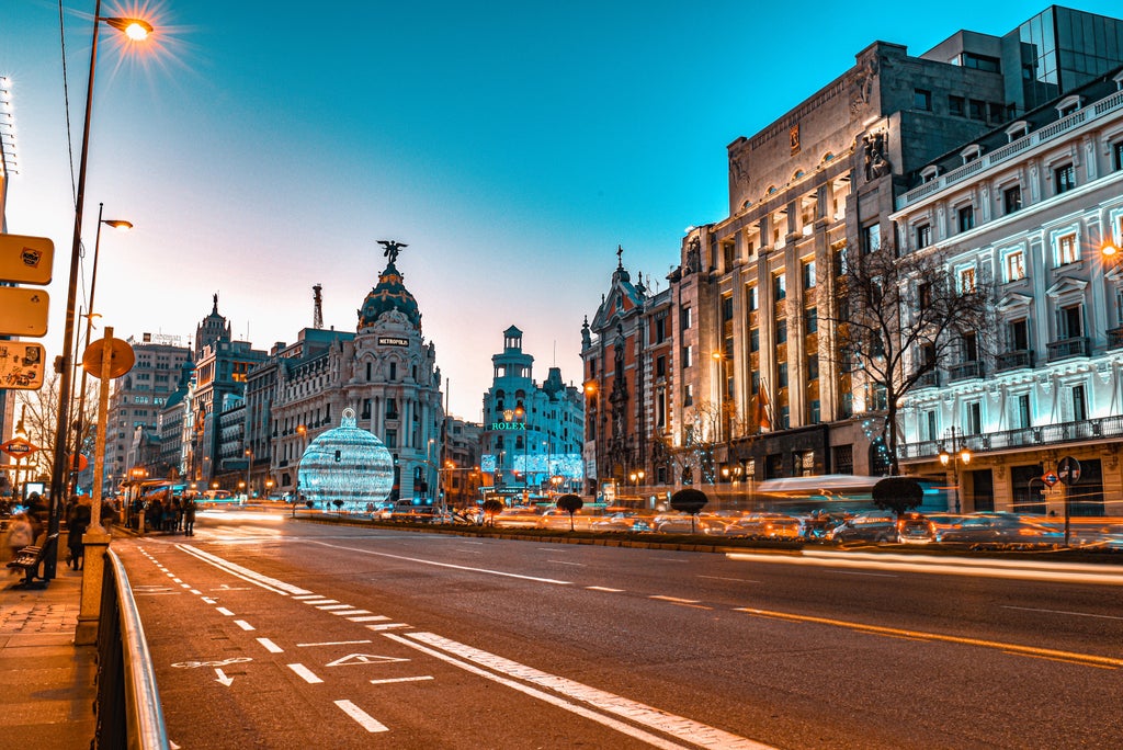 Historic Royal Palace of Madrid with ornate Baroque architecture, elegant fountains, and manicured gardens under bright blue skies