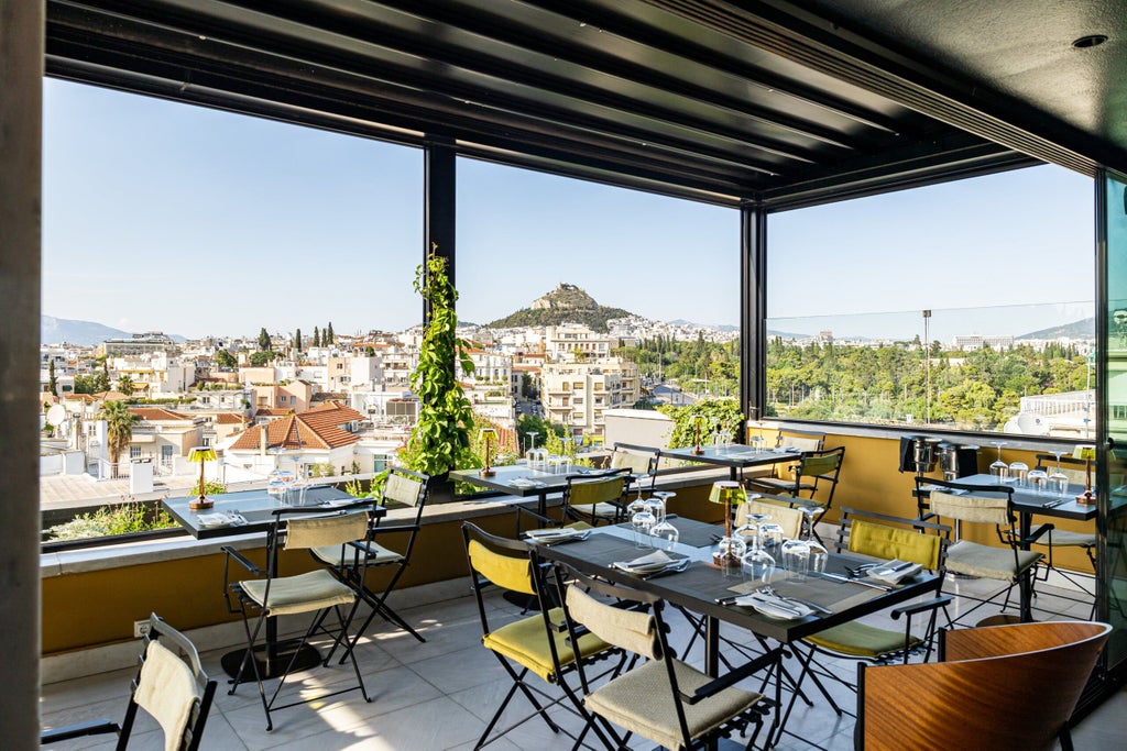 Modern boutique hotel facade with elegant glass balconies, warm lighting, and sleek architectural design in central Athens at dusk