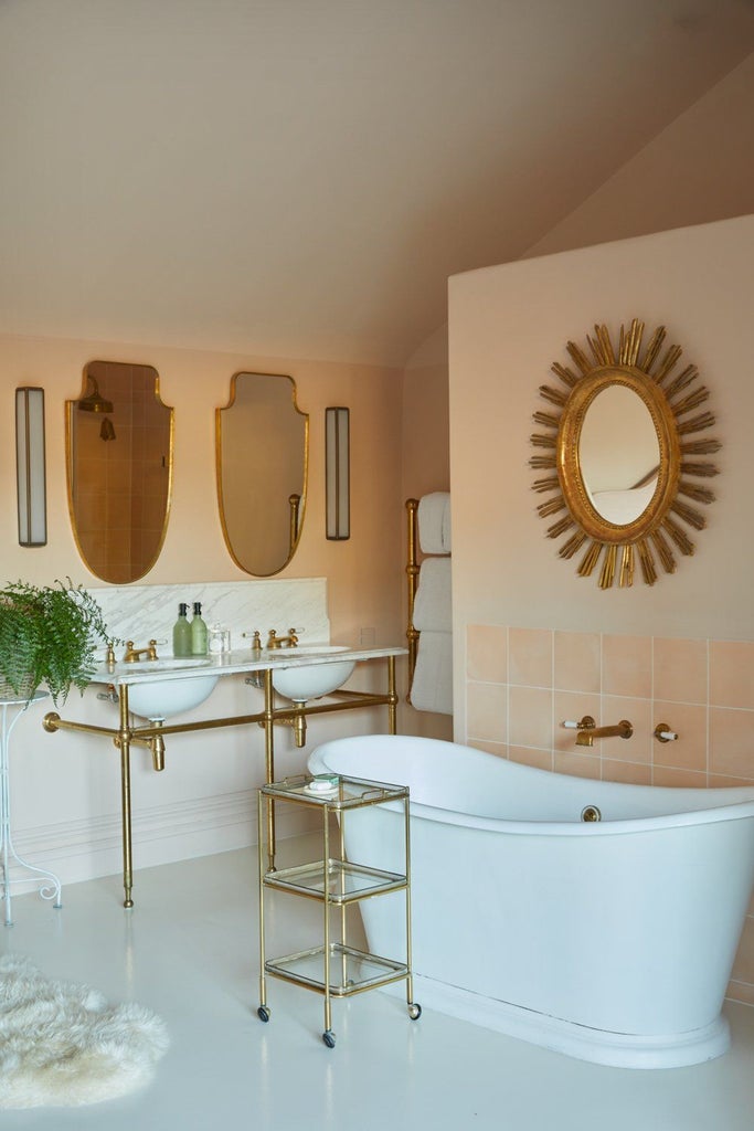 Elegant garden-view bedroom with soft green thyme-inspired decor, plush white linens, and natural light streaming through expansive windows in a UK boutique hotel.