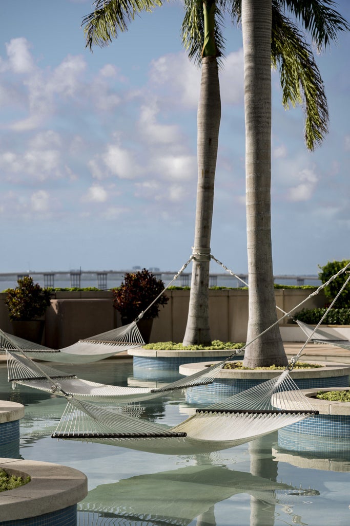 Beachfront luxury hotel tower with floor-to-ceiling windows, private balconies and infinity pool overlooking Miami's pristine coastline