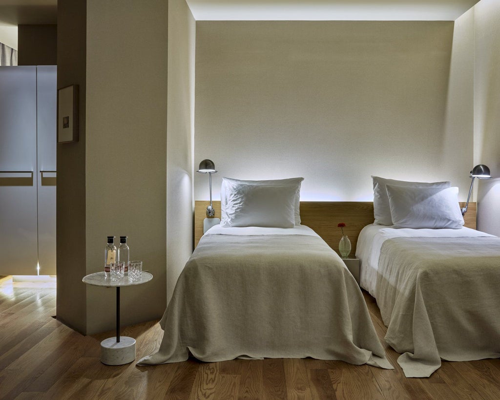 Modern luxury hotel room with sleek minimalist design, warm wood tones, contemporary furnishings, and expansive city view in Barcelona, Spain, showcasing elegant comfort